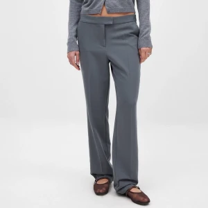 Grå kostymbyxor - Snygga grå kostymbyxor med låg midja och rak passform. Byxan är helt ny utan användning i storlek 36 från NA-KD