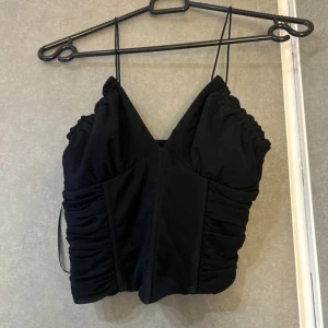 Svart korsett med smala axelband - Topp som är korsett liknande. Mindre i storleken nästan aldrig använd 