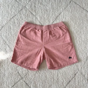 Rosa shorts från Stussy - Säljer ett par snygga rosa shorts från Stussy. De har en elastisk midja och en liten logga på framsidan. Perfekta för en avslappnad stil. 🩳