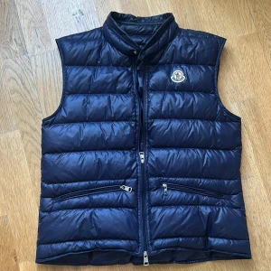 Moncler gui väst  - Riktigt snygg moncler gui väst i navyblått. Storlek 1- S . Skick 9/10 . Äkta såklart nfc osv fungerar! Pris 2399 kan gå ner i pris vid snabb affär!