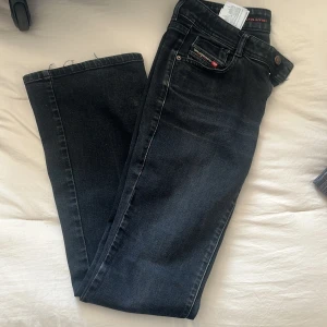 Svarta jeansbyxor från Diesel - Snygga svarta jeansbyxor från Diesel med klassisk femficksdesign och knappgylf. Perfekta för en stilren look. Passar bra till både vardag och mer uppklädda tillfällen.