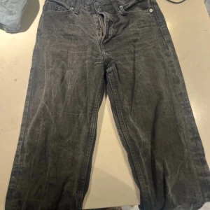 Svarta vintage jeans - Säljer ett par svarta vintage straight jeans med hög midja. De är tillverkade i denim och har en klassisk design med dragkedja och knappar. Straight 