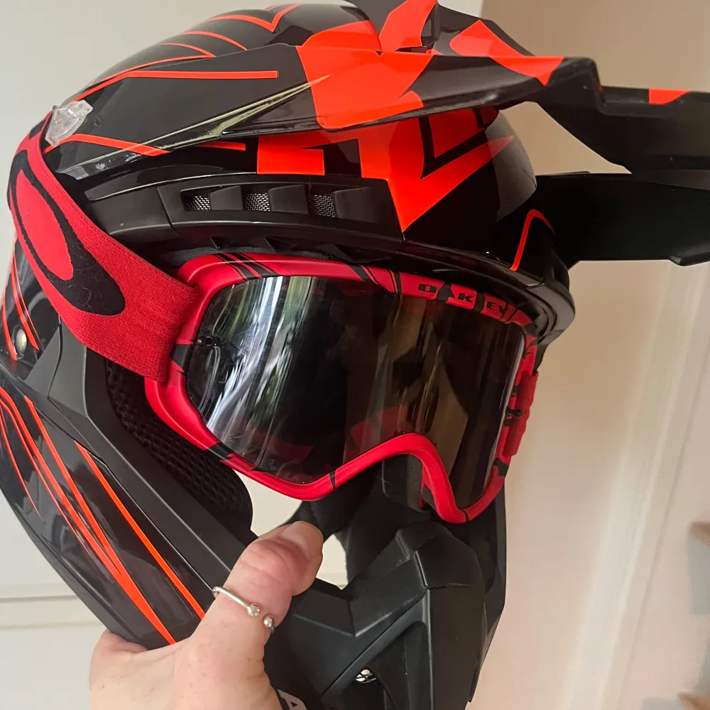 Säljer en cool svart och röd hjälm från Airoh med matchande röd och svart mönstrad design. Hjälmen har en skärm och är perfekt för motocross eller moped. Inkluderar även ett par röda glasögon från oakley och svarta handskar från 100% i storlek M. Nypris för dessa 2200+600+369=3 169:- Använda under en knapp månad, så väldigt fint skick! Några mindre ytliga repor finns, aningen noppigt på insidan av hjälmen om man granskar noga, närbilder finns på allting och kan fås vid intresse. Skambud undanbes. Asusteet.