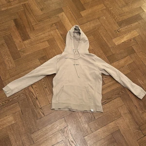 Beige hoodie från Les Deux - Säljer en stilren beige hoodie från Les Deux. Tröjan har en klassisk design med en känguruficka och justerbar huva. Perfekt för en avslappnad look. Storlek S. Nypris 1200 mitt pris 350