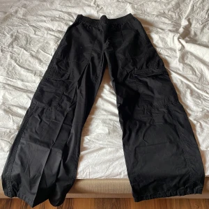 Svarta cargopants - Säljer ett par svarta cargopants med loose fit och flera praktiska fickor. Byxorna har en elastisk midja för extra komfort och är perfekta för en avslappnad stil.