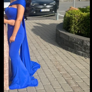 Klänning i storlek 34/36 - Mörkblå klänning i stretchigt material som smickrande formar sig efter kroppen. Passar storlek 34, 36 och en liten 38. Liten fimp skada som jag har sytt, så det syns inte bra.