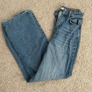 Jenas - jeans i ljusblå denim med raka ben och femficksmodell. Jeansen har knappgylf och den ikoniska läderpatchen bak i midjan. Perfekta för en avslappnad och tidlös look.