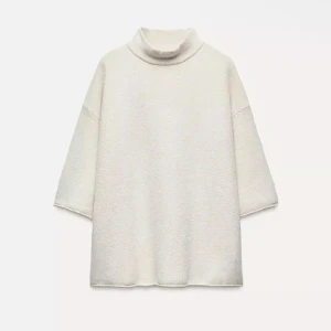 Vit polotröja med lös passform - Superfin vit polotröja med oversized och loose fit. Tröjan har trekvartsärmar och hög krage, perfekt för lager-på-lager. Materialet är mjukt och känns lite stickat, vilket gör den extra mysig. Enkel att styla till både jeans och kjol.