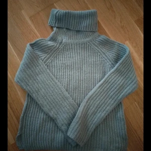 Grå ribbstickad polotröja - Mysig grå polotröja med ribbstickat mönster och hög krage. Från Gina Tricot 