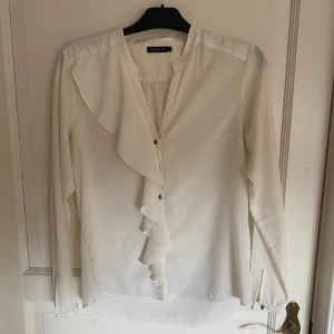 Vit volangblus  - Vit volangblus med guldknappar, använd men i gott skick utan defekter