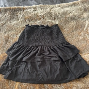 Svart volangkjol från Vila XS - Svart och skön kortkjol från Vila med dubbla volanger. Stretchig och mjuk.