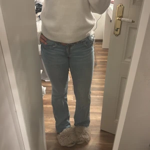 Ljusblå bootcut jeans från Gina Tricot - Säljer ett par ljusblå jeans från Gina Tricot i storlek 164. Jeansen har bootcut-modell, klassiska fem fickor och rå, fransig midja för en cool vibe. Tillverkade i bomull och passar perfekt till sneakers eller boots.