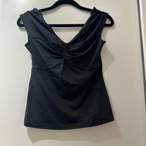Svart topp med twistad front - Svart topp från new yorker som inte kommer till användning. Aldrig använd