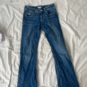 Blå bootcut jeans från Gina Tricot - Snygga low waist jeans från Gina Tricot i bootcut-modell med markerade sömmar och fina detaljer på bakfickorna. Perfekta nu till hösten. Fint skick (inga hål eller fläckar) skriv om du är intresserad, priset kan diskuteras 