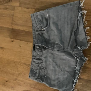 Grå jeansshorts med fransig kant 157 - Snygga grå jeansshorts från 157 med fransig rå kant och klassisk femficksmodell. Perfekta för en chill sommarlook och passar till allt.