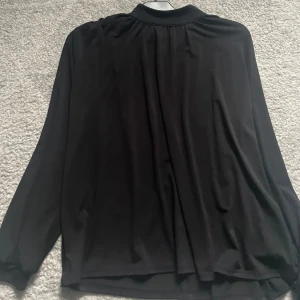 Svart långärmad blus - Svart långärmad blus med rynkat på axlarna. Pris går att diskutera. Använd en gång