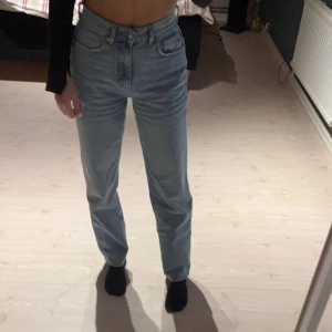 Blå high waist jeans från Gina Tricot - Säljer ett par ljusblå jeans från Gina Tricot i storlek 32. De har hög midja, raka ben och femficksdesign. Fint skick, använda fåtal gånger. 