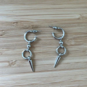 Silvriga örhängen med spikes - Coola silvriga örhängen med ringar och spetsiga spikes som hänger ned. Perfekta för dig som vill ha en edgy och trendig stil. De har knappt används är Såå fina!!