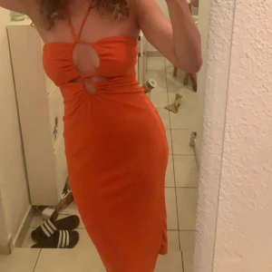 Orange tight klänning med cut-outs - Säljer en orange, tight klänning med snygga cut-outs framtill från Biancas kollektion med gina tricot. 