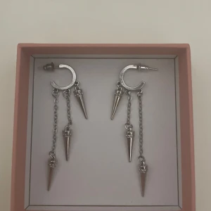 Silvriga örhängen med kedjor och spikes - Coola silvriga örhängen med halvcirkelformad bas och hängande kedjor med spetsiga spikes / taggar. Så fina! 💞 kontakta mig om du vill ha bild på hur dem ser ut på❤️