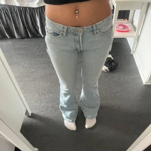 Ljusblå Zara bootcut jeans - Säljer ett par ljusblå Zara jeans med bootcut passform och låg midja. Jeansen har klassisk femficksdesign, dragkedjegylf och råa för en avslappnad vibe. Tillverkade i äkta denim som ger en snygg vintagekänsla. De är ifrån Zara och är i storlek 36 (S). Enda defekten är att de är lite sliten ner till vid fötterna men annars i ett mycket bra skick. 