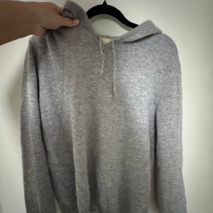 Grå kashmirhoodie från Sayless! - Säljer åt min bror - Supermjuk grå hoodie från Sayless i kashmir. Klassisk modell med huva och snörning,Långärmad och i neutral ljusgrå!💙
