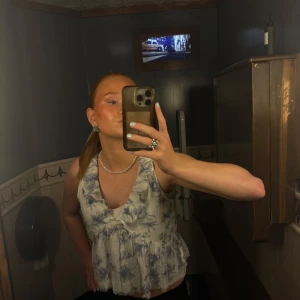 Blommig volangblus från Gina Tricot - Supersöt blus från Gina Tricot i vitt med blått blommönster. Nästan helt ny