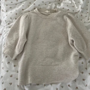 Beige stickad tröja med puffärm - Superfin beige stickad tröja med puffiga trekvartsärmar från H&M. Bra kvalitet, lite nopprig men inte så farligt.