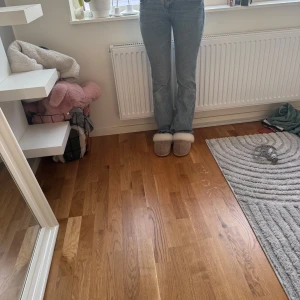 Blå bootcut jeans med detaljer - Säljer ett par snygga blå bootcut jeans. Jeansen har coola detaljer på bakfickorna och klassisk femficksdesign. Perfekta för dig som gillar en retro vibe och vill ha ett par jeans som sticker ut lite extra. Har dock ett hål där bak men är lagad och jeans under hålet.