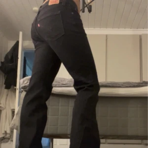 Levi's Superlow Bootcut jeans svart - Svarta Levi's Superlow Bootcut jeans med låg midja och klassisk femficksdesign. Jeansen har bootcut-ben och är tillverkade i mjukt denim. Snygga kontrastsömmar och ikonisk Levi's-lapp bak i midjan. Perfekta för dig som gillar 00-talsvibe.