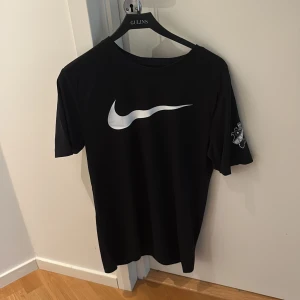 Svart AIK x Nike t-shirt S - Svart t-shirt från Nike med stor vit swoosh på bröstet och AIK:s klubbmärke på ärmen. På ryggen står det 'Allmänna Idrottsklubben' i vitt. Klassisk passform och mjuk bomullskänsla, perfekt för dig som älskar AIK och sportig stil. Den är helt ny , med lappen kvar. Aldrig använd men säljs då den är i fel storlek för mig .