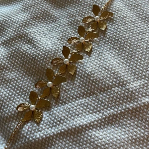 Guldigt blomhalsband med pärlor - Säljer detta superfina halsband i guld med stora blommor som har pärlor i mitten!💞💕 Oanvänt, säljer då det inte kommer till användning.