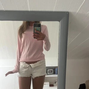 Ljusrosa långärmad tröja - En enkel och stilren ljusrosa långärmad tröja med rund halsringning. Tröjan är tunn och mjuk, perfekt för lager-på-lager eller som den är. Passformen är normal och materialet känns lätt och bekvämt mot huden.