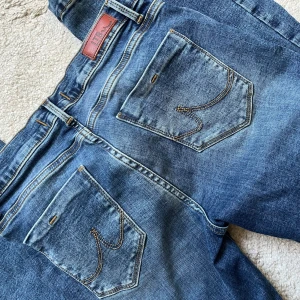 Blå bootcut jeans från LTB W28 L32 - Snygga blå lågmidjade jeans från LTB med bootcut passform och klassiska detaljer. Jeansen har fem fickor, kontrastsömmar och en lätt tvättad look. Perfekta för dig som gillar en avslappnad men ändå trendig stil. Använda ett fåtal gånger.