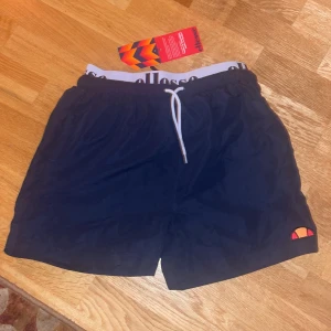 Badbyxor Ellesse HELT NYA!!! - Mörkblå badbyxor från Ellesse, aldrig använda, säljer för att dom var lite små på mig. Nypris 500kr