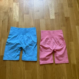 Sömlösa träningstights shorts blå & rosa - Två par sömlösa cykelshorts i stretchigt material, ett par i klarblått och ett par i ljusrosa. Båda har hög midja och scrunch-detalj bak för extra shaping. Perfekta för gymmet eller löprundan, sitter tight och bekvämt hela passet. 80kr/styck