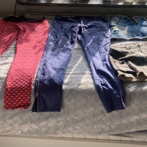 Träningsleggings och blåa byxor mix - 👖 Byxor & Shorts  📍 Storlek: 38/40 📦 Skick: Bra 💰 Pris: 80 kr/st 	1.	Svarta skinnimitation-byxor med detaljer – 30kr 	2.	Röda byxor med struktur – stretchiga och unika 	3.	Mörkblå smala byxor med dragkedja vid benslut 	4.	Jeansshorts – slitna med fransade kanter 	5.	Camouflage-kjol – råa kanter, cool stil – Pris: 60 kr 	6.	Mörkblå kjol – sportig och bekväm – Pris: 60 kr  ⸻  📩 Skicka meddelande vid intresse! Kan mötas upp eller skicka mot fraktkostnad. Paketpris kan diskuteras vid köp av fle