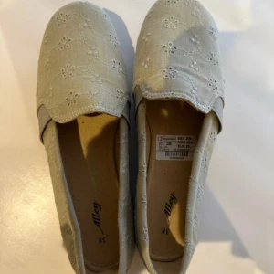 Gröna broderade ballerinaskor Alley - Snygga beige ballerinaskor från Alley med broderade blommor och rund tå. Skorna har platt sula, vilket gör dem både lätta och bekväma. Perfekta för vår och sommar!
