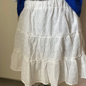 Vit volangkjol  - Superfin vit kjol med volanger och broderade hålmönster. Passar mig perfekt som har storlek M!❤️