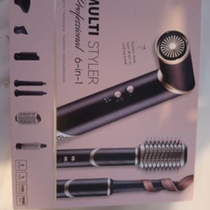 Multi Styler 6-in-1 hårstyler - Multi Styler 6-in-1 med flera utbytbara borst- och munstycken för att skapa olika frisyrer. Svart och guld design, innehåller rundborste, locktillbehör och fönmunstycke. Perfekt för att fixa volym, lockar eller släta längder. Levereras i originalförpackning.