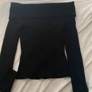 Svart offshoulder ribbad stickad topp i storlek s  - En svart fin stickad topp med offshoulder med långa armar i storlek s (okäntmärke) priset kan diskuteras 