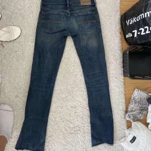 Levis bootcut jeans i mörkblå denim - Mörkblå Levis jeans med bootcut passform och slitna detaljer vid bensluten. Klassisk femficksmodell med snygga slitningar framtill och bakfickor med Levis-logga. Jeansen har låg midja och är tillverkade i mjuk bomullsdenim.