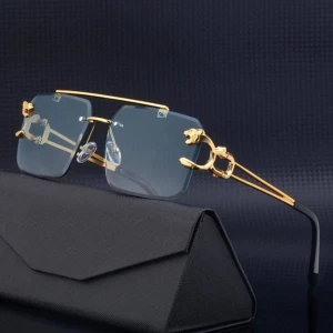 Guldiga kantlösa glasögon med blåton - Unika kantlösa glasögon med fyrkantiga blåtonade linser och detaljerade guldfärgade skalmar med panterhuvuden. Snygg och lyxig design som sticker ut, perfekt för dig som vill ha något extra. Säljes med svart fodral. PRISET KAN DISKUTERAS!