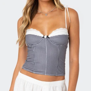 Rutig korsettopp med spets och rosett - Supersöt korsettopp från edikted! Den är i storlek M, men liten i storleken så skulle säga xs/s. Den är helt ny med lapp kvar, endast testat och säljer för att den inte passade mig i storlek. 