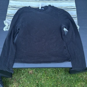 Svart långärmad tröja - En basic svart långärmad tröja. Enkel och stilren modell med rund halsringning, perfekt att matcha med jeans eller kjol. Tvättas innan.