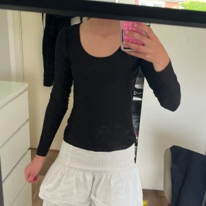 Svart långärmad topp från Monki - En svart, figurnära långärmad topp från Monki i stretchigt och mjukt material. Toppen har rundad urringning och enkel, stilren design som är lätt att matcha. Perfekt för lager-på-lager eller som den är. Storlek S. säljer då jag inte använder det längre. Priset går att diskuteras.
