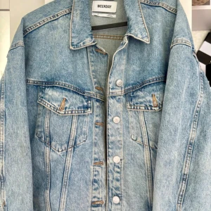 Ljusblå jeansjacka från Weekday - Säljer en klassisk ljusblå jeansjacka från Weekday i storlek S. Jackan har raka linjer, två bröstfickor med lock och knappar framtill. Perfekt oversized fit för en chill och trendig look. Tillverkad i slitstarkt denim-material.