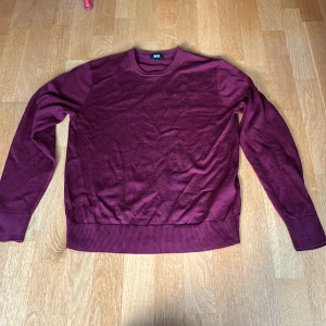 Vinröd merino tröja från Uniqlo XS - En stilren vinröd tröja från Uniqlo i storlek XS. Tröjan har rund halsringning, långa ärmar och ribbade muddar vid ärmslut och nederkant. Perfekt för lager-på-lager.