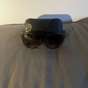 Ray-Ban Wayfarer brunmelerade solglasögon - Tja säljer dessa Ray-Ban Boyfriend solglasögon. Mörka glas och diskret Ray-Ban-logo på linsen. Kommer med original svart fodral. Perfekta för att lyfta din stil i solen. Köpta förra sommaren för 1800, säljer för 649kr. Hör av er vid intresse.