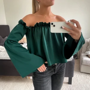 Mörkgrön off-shoulder tröja med utsvängda armar - Säljer denna fina gröna off-shoulder topp med utsvängda, långa armar. Superbra skick på denna topp ❤️